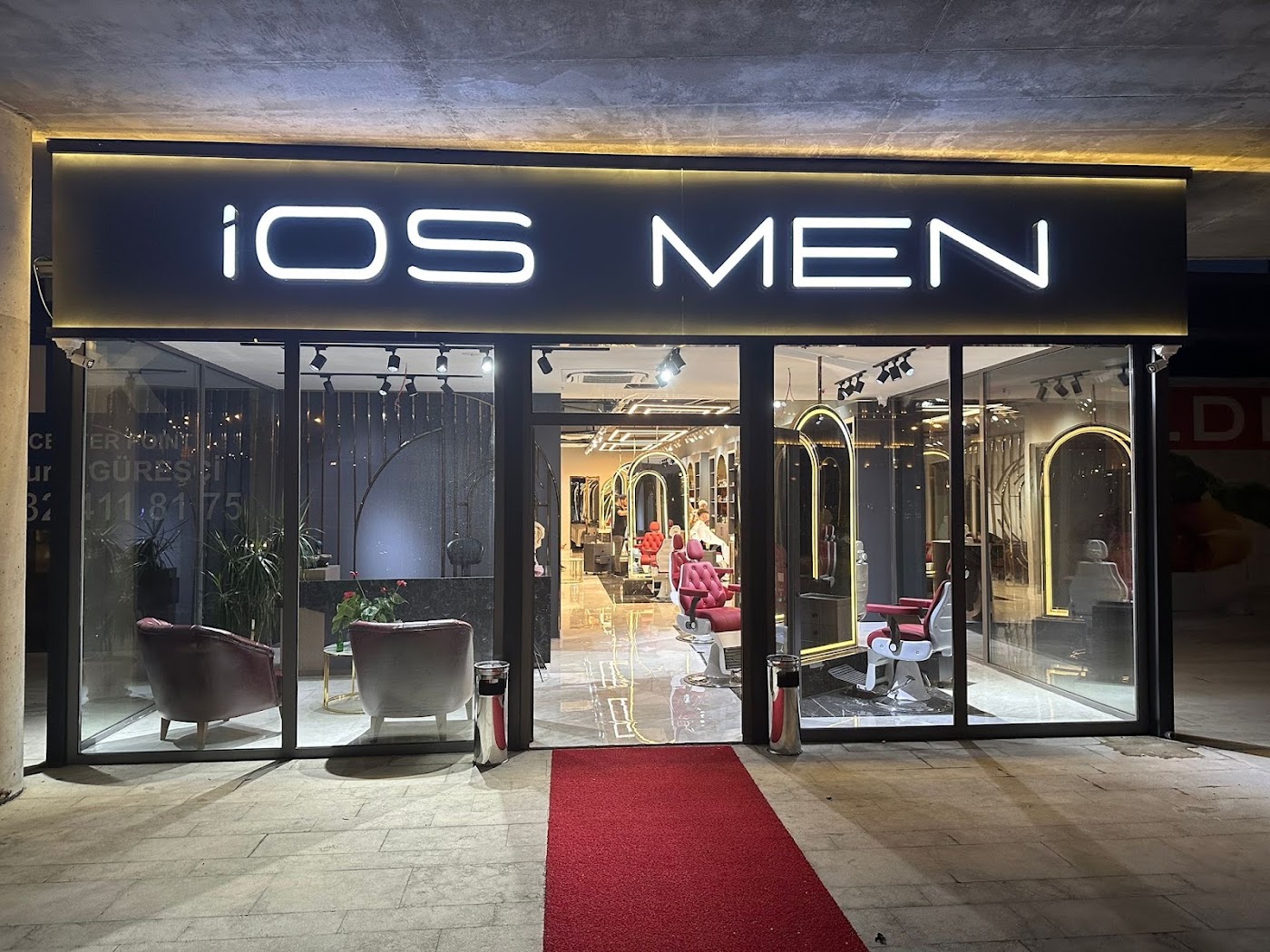 İos Men VIP Erkek Kuaförü — gece cephesi, LED ışıklı İOS MEN tabelası ve kırmızı halı girişi